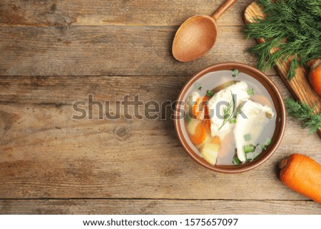 Delicious fish soup served on wooden table, flat lay. Space for text