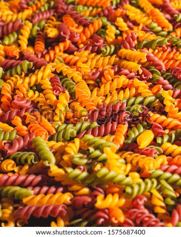Uncooked tricolore fusilli pasta twist shapes background. Stock photo pasta twist shapes.
