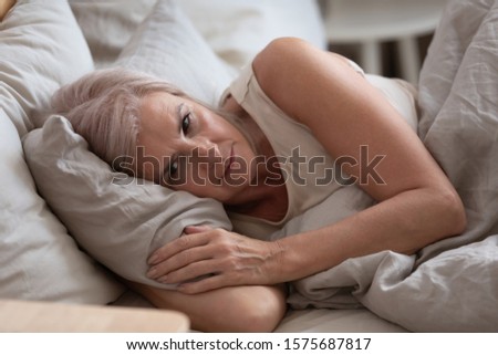 Close up view sleepless middle-aged woman lying in bed suffers from insomnia sleep disorder cant sleep till morning, depressed elderly female looking upset thinking about life, health troubles concept Royalty-Free Stock Photo #1575687817