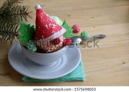 Pink and green ice cream for Christmas. Creative dessert for children. The red cap and green Christmas trees are made of marshmallow.