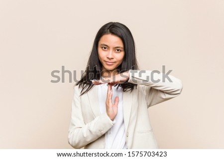 Young business chinese woman showing a timeout gesture.
