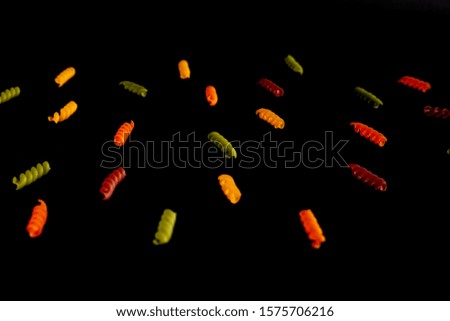 Tricolor pasta on a black background. Stock photo of pasta.