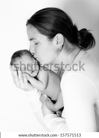 Mother kissing her child studio shot