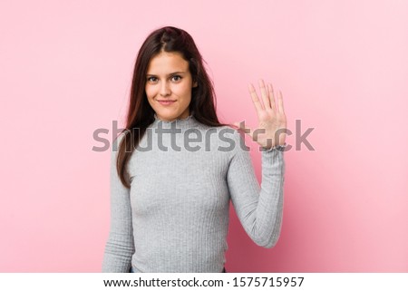 Young cute woman smiling cheerful showing number five with fingers.