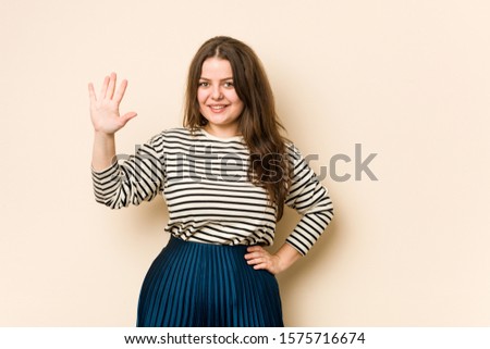 Young curvy woman smiling cheerful showing number five with fingers.
