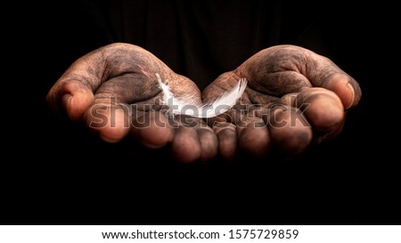 Hand holding a white feather on dark background.
Do bad things to protect good thing.
Conceptual art photography. 