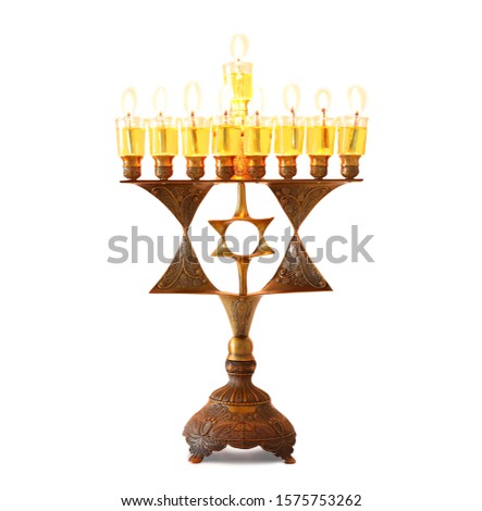 religion image of jewish holiday Hanukkah with bronze menorah (traditional candelabra) and colorful oil candles over isolated white background