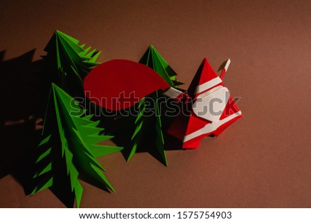 Origami santa claus with a bag of gifts. Cartoon postcard. Stock photo handmade paper.