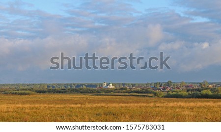 Autumn panorama overlooking the ancient Orthodox church, bright sky, rich colors.