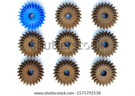 The blue Bevel Gears stand out from the many brown crowd on a white background. Leadership, identity, initiative, strategy, conflict, different ideas, business success concepts
