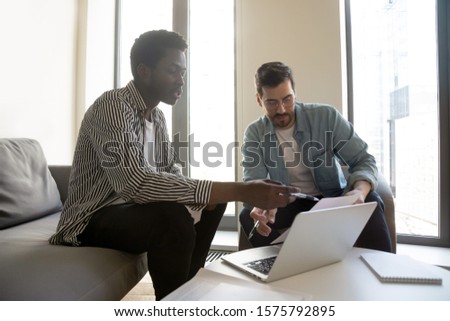 African caucasian entrepreneurs met in modern office solving common issues using last financial data and corporate pc application analysing information thinking together, teamwork partnership concept
