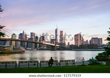 Sunset over New York City, filming on the south side of the Brooklyn Bridge, Brooklyn Bridge in the frame, water surface, embankment.Photos from my month tour of America