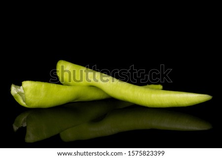 Group of two halves of hot green pepper banana isolated on black glass