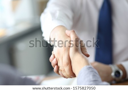 Closeup of business handshake after signing new contract at the office.