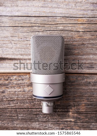 Large diaphragm condenser studio microphone. On a wooden background.