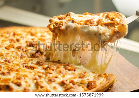 Stock image of Very cheesy pizza slice .Pizza is a savory dish of Italian origin, consisting of a usually round, flattened base of leavened wheat-based dough topped