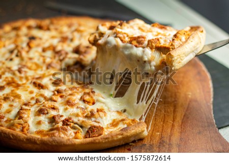 Stock image of Very cheesy pizza slice .Pizza is a savory dish of Italian origin, consisting of a usually round, flattened base of leavened wheat-based dough topped