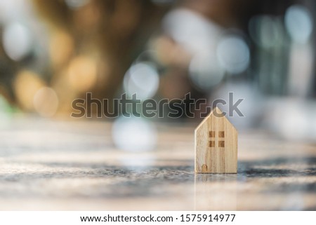 Wood house model on  wood background, a symbol for construction , ecology, loan, mortgage, property or home.
