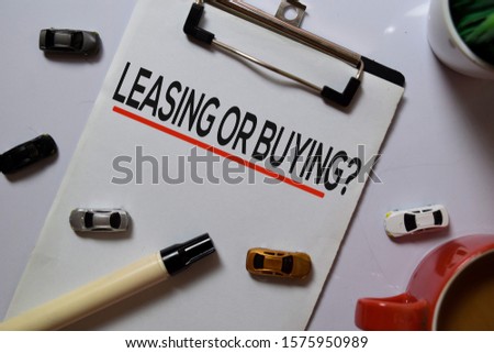 Leasing or Buying? write on Paperwork with Car toys isolated on white board background.