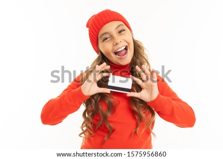 smiling european cute girl holding a credit card in her hands on a white background