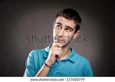 young man thinking on a grey background