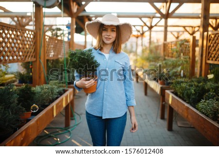 Female customer buying flower in a pot, floristry
