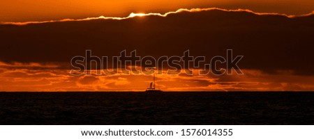 Natural marine landscape with amazing sunset over the ocean in Tenerife Canary Island Spain. Summer exotic vacation postcard from tropical island. Wonderful orange sunrise over the water behind clouds