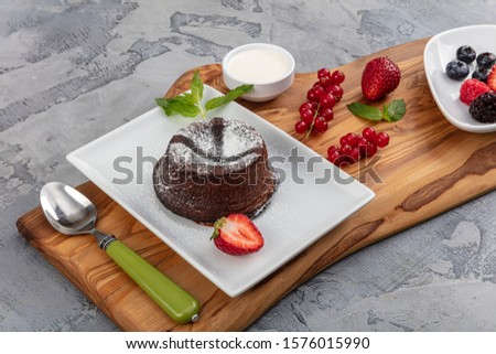 Close up Photograph of a chocolate souffle. Chocolate fondant lava cake with strawberries.