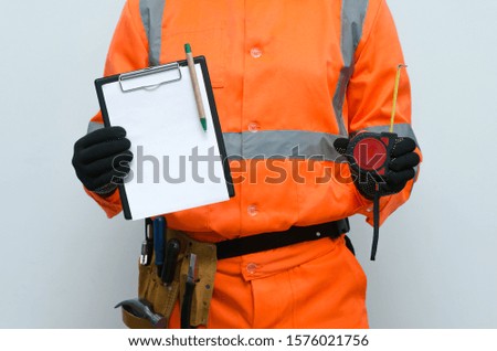 Fix list mock up. Construction to do list. Worker holding in hand a blank paper page with copy space.