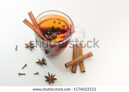 A mug of hot homemade mulled wine with spices and orange.