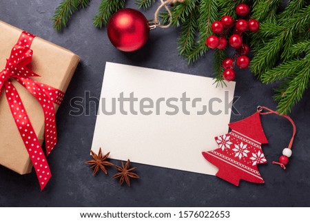Christmas card with paper, gift box and fir tree branch on stone background. Holiday mockup. Top view - Image