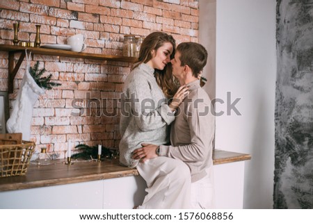 Young couple at home in the kitchen on Christmas time