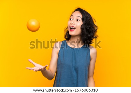 Asian young woman holding an orange