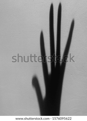 Shadow of human palm on white wall