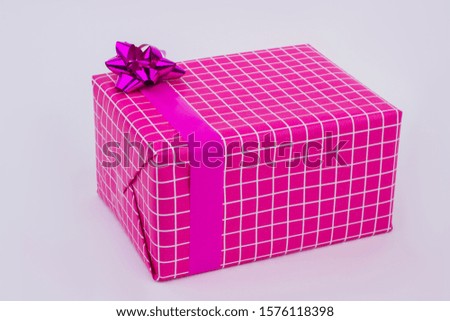 Beautiful big gift box with satin ribbon. Pink checkered present box with bow. Birthday gift background.