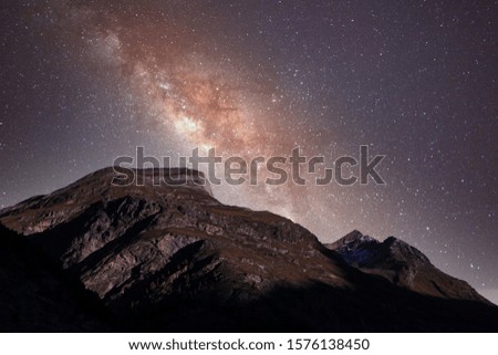 Rocky mountain peaks at dusk with stars and milky way.