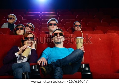 Group of people in 3D glasses watching movie in cinema