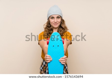 Young skater blonde girl over isolated background with happy expression