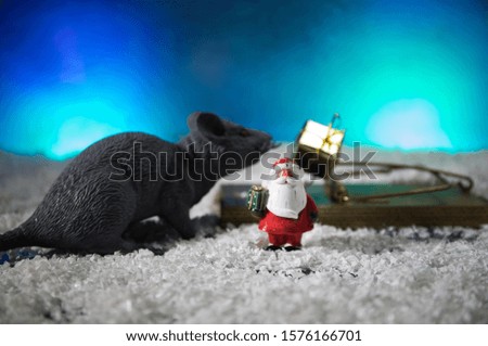decorative cute brown rat around with a Christmas decor and Santa Claus. The rat is a symbol Of the new year 2020