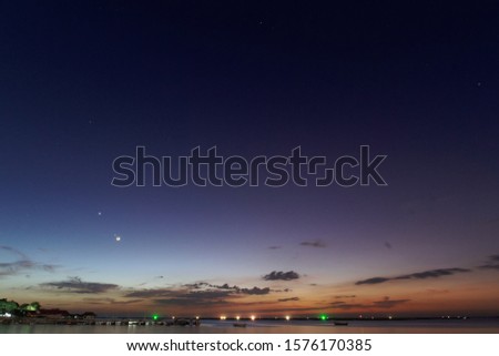 sunset​ over​ sea​ with​ moon​ and​ star​