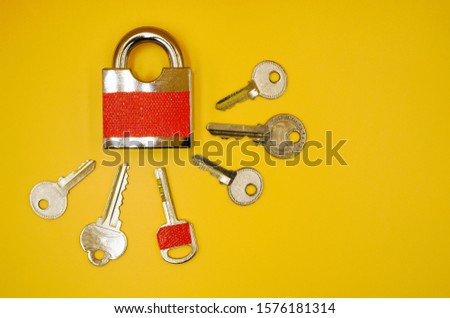 one key with red sticker among many keys which is the same color of padlock , mistake proofing or poka yoke concept as symbol for remind to use the right key ,isolated on yellow background