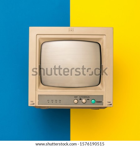 Retro TV on yellow and blue background. The view from the top. Vintage electronics.