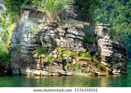 Pictures of geological structure of limestone layer in Na Hang lake in Tuyen Quang province, Vietnam. This natural lake has a blue watercolor. It lies between the majestic cliffs. Every year this plac