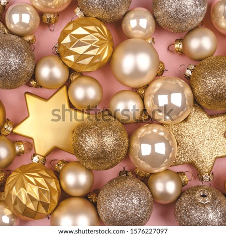 Festive pink background with gold and silver Christmas stars and balls. Flat lay, top view.
