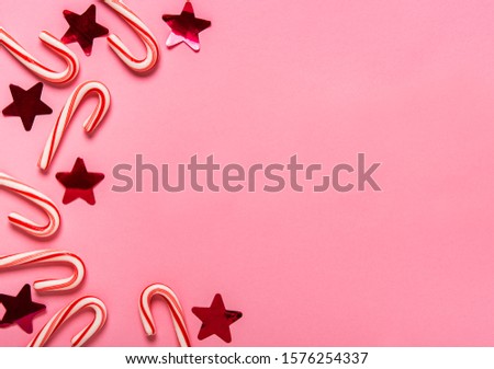 Christmas candy cane and decorations on pastel pink background. Flat lay and top view