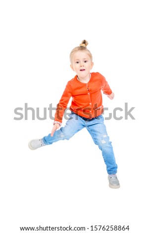 A portrait of a cute bright girl jumping in the studio over the white background. Kids, casual fashion.
