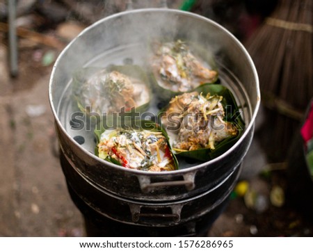 Thai food wrapped in banana leaves on a charcoal stove
