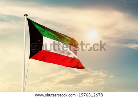 Kuwait national flag cloth fabric waving on the sky with beautiful sun light - Image