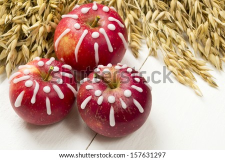 Three red sugar glazed winter apples as a table decoration and fresh oats
