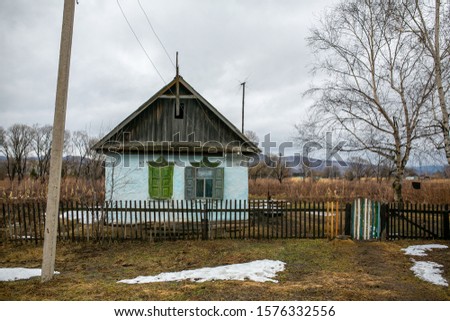 Russian village. Wooden farmhouse behind a wooden picket fence. Hut in the Russian village.